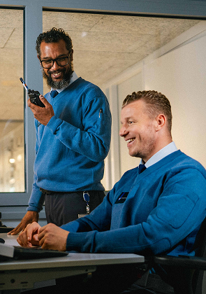 Twee beveiligingsmedewerkers op werkplek met portofoon