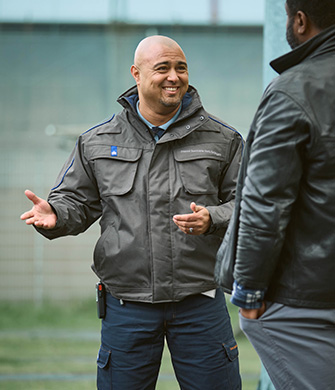 Medewerker praat vriendelijk met man buiten