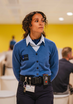 Medewerkster staat in ruimte met collega’s