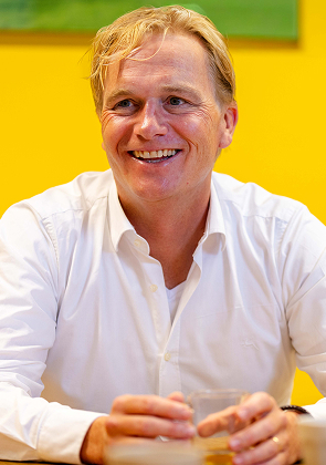 Man zit aan tafel tijdens overleg