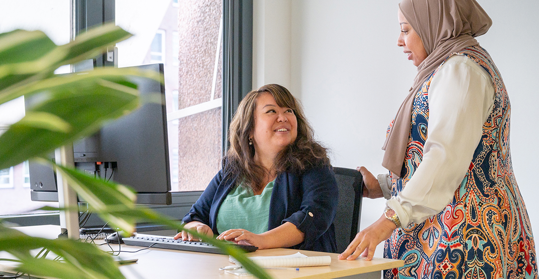 Collega's praten bij een bureau op kantoor