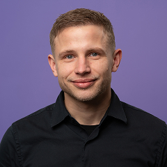 Persoon in zwart shirt tegen paarse achtergrond