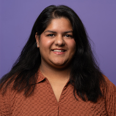 Portret van een glimlachende vrouw tegen paarse achtergrond