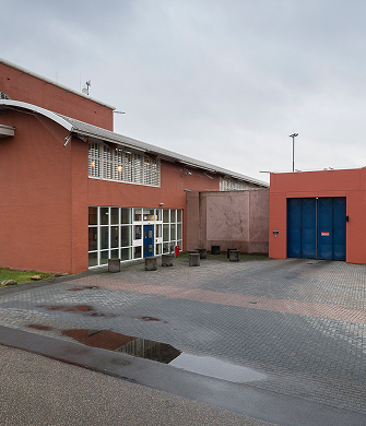 Begeleider praat rustig met man in sportzaal hier