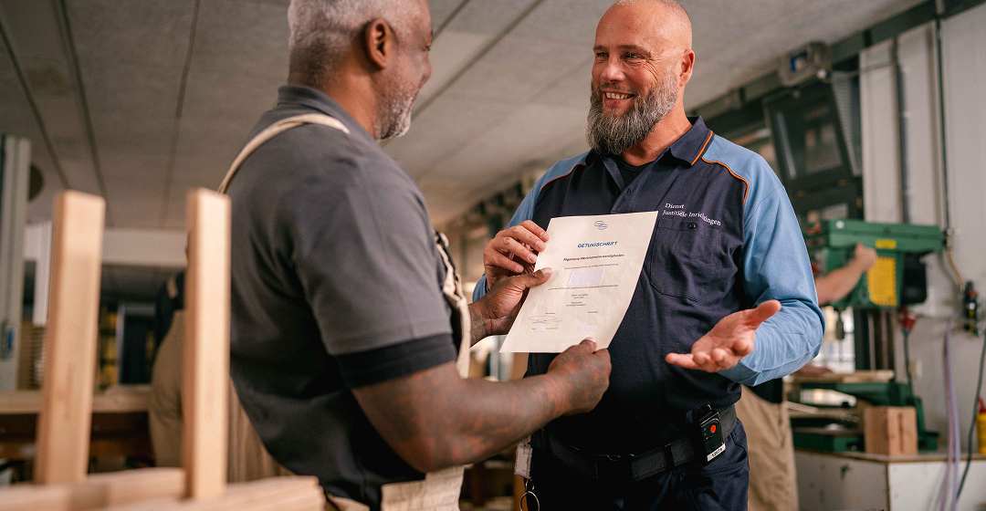 Medewerker overhandigt certificaat in werkplaats