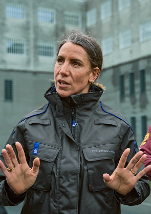 Vrouw in uniform legt iets uit met gebaren