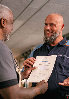 Medewerker overhandigt document aan bewoner