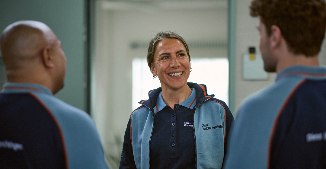 Drie collega's in gesprek op kantoor