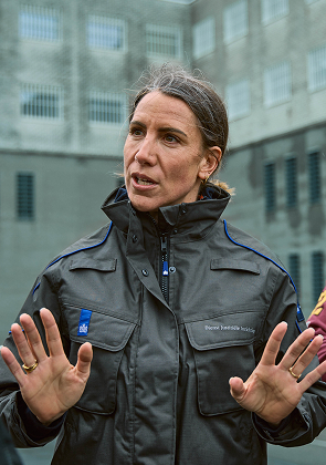 Begeleider spreekt met groep in gevangenisruimte