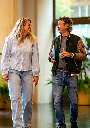 Collega’s lopen en praten in kantoorhal