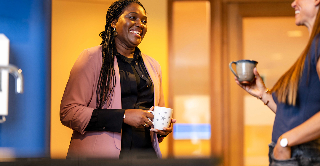 Collega’s praten bij koffie op kantoor