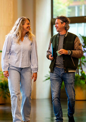 Collega’s lopen pratend door modern kantoorpand