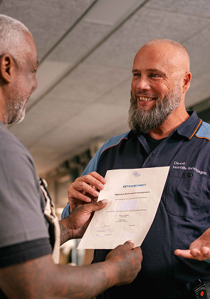 Medewerker overhandigt document en glimlacht blij