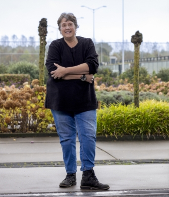 Persoon staat in deuropening bij tuin