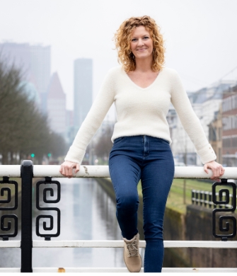Een vrouw staat voor een trainingsgroep bij het Opleidingsinstituut DJI