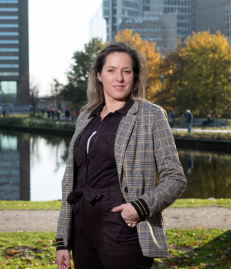 Een vrouw staat buiten en kijkt in de camera