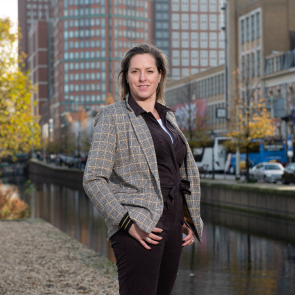 Persoon bij kanaal met gebouwen erachter