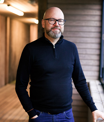 Kaalkop met bril en baard in donker trui