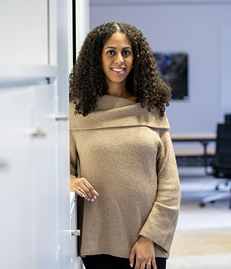 Vrouw staat glimlachend in moderne kantoorruimte!!