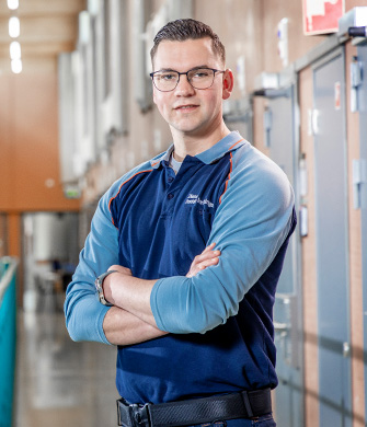 Man in werkruimte met armen over elkaar