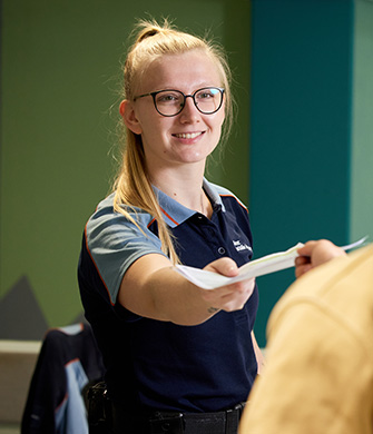 Medewerker overhandigt document aan bezoeker