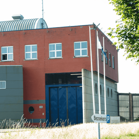 Ingang gevangenis met bezoekersbord
