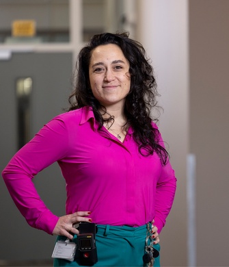 Vrouw in roze shirt met arm in zij