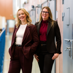 Twee vrouwen staan in een gevangenis gang