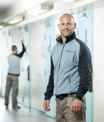 Medewerker in gang, collega maakt deur schoon