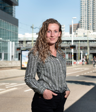 vrouw staat buiten en kijkt in de camera