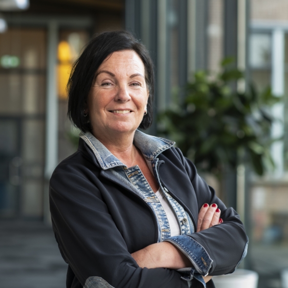 Zelfverzekerde vrouw staat binnen met armen kruis!