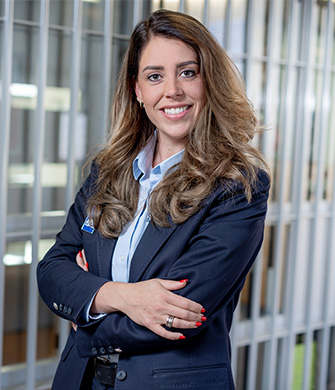 Zakelijke vrouw lacht met armen gekruist op kantoor