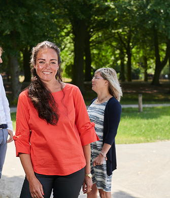 Vrouw met rood shirt kijkt in camera