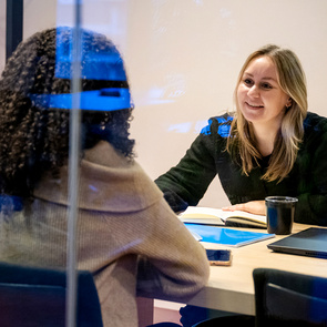 Twee collega’s in gesprek aan een vergadertafel