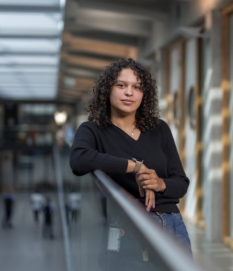 Persoon leunt op reling in modern gebouw