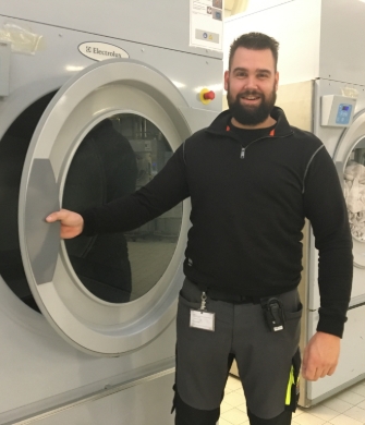 Persoon bij industriële wasmachine