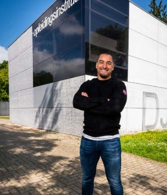 Persoon met armen gekruist voor modern gebouw Provide your feedback on BizChat