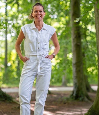 Vrouw lacht naar camera in bos