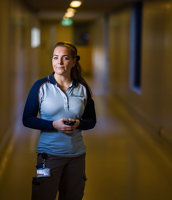 Medewerker loopt door een gang met portofoon