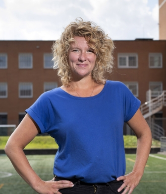 Een vrouw staat in een gang van de penitentiaire inrichting Alphen aan den Rijn