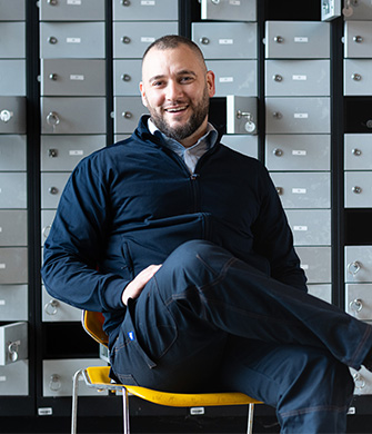 Medewerker zittend voor lockers in inrichting