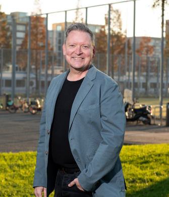 man staat buiten kijkt in de camera