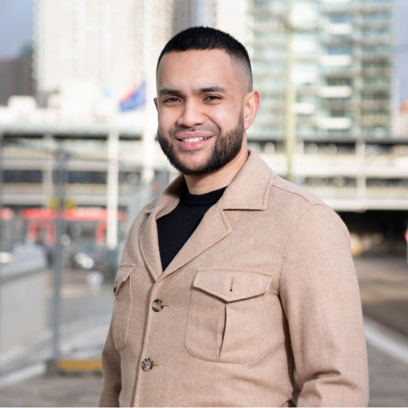Persoon staat buiten langs stadse straat en gebouwen