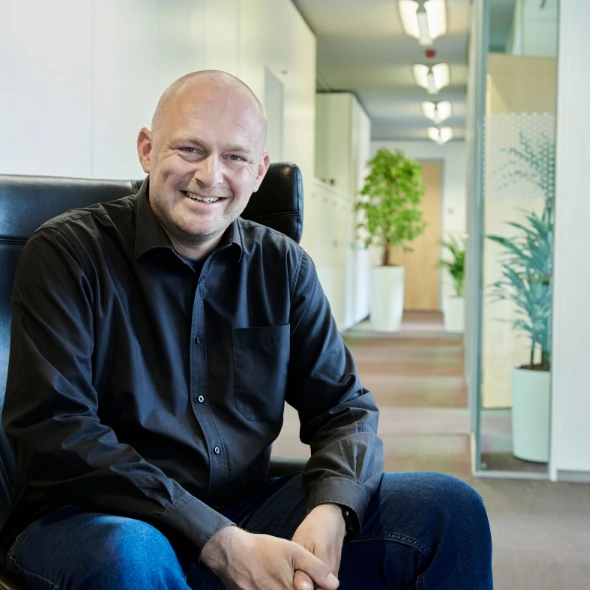 Persoon zit in stoel in lichte kantoorruimte