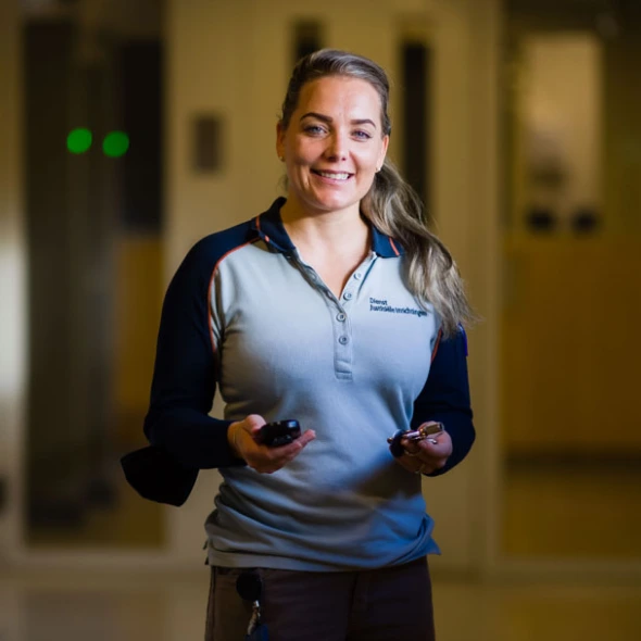 Medewerker loopt door gang met portofoon in hand