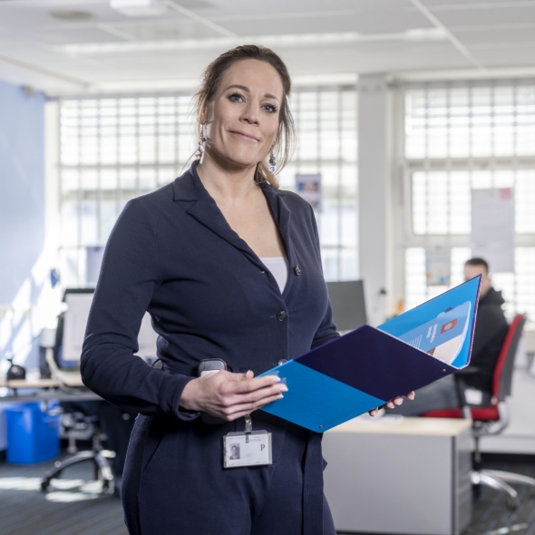 Zakelijke vrouw houdt map vast in lichte kantoorruimte