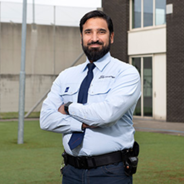 Man in lichtblauw overhemd met armen gekruist