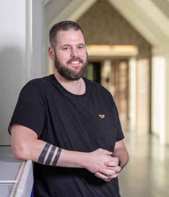 Een man staat buiten bij een kliniek en kijkt in de camera