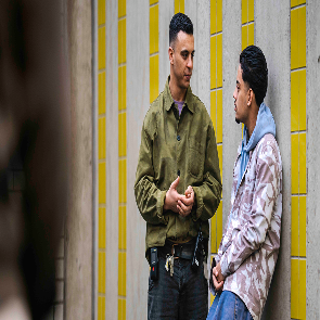 Twee mannen in gesprek bij een muur