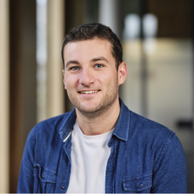 Smiling man in casual shirt standing indoors